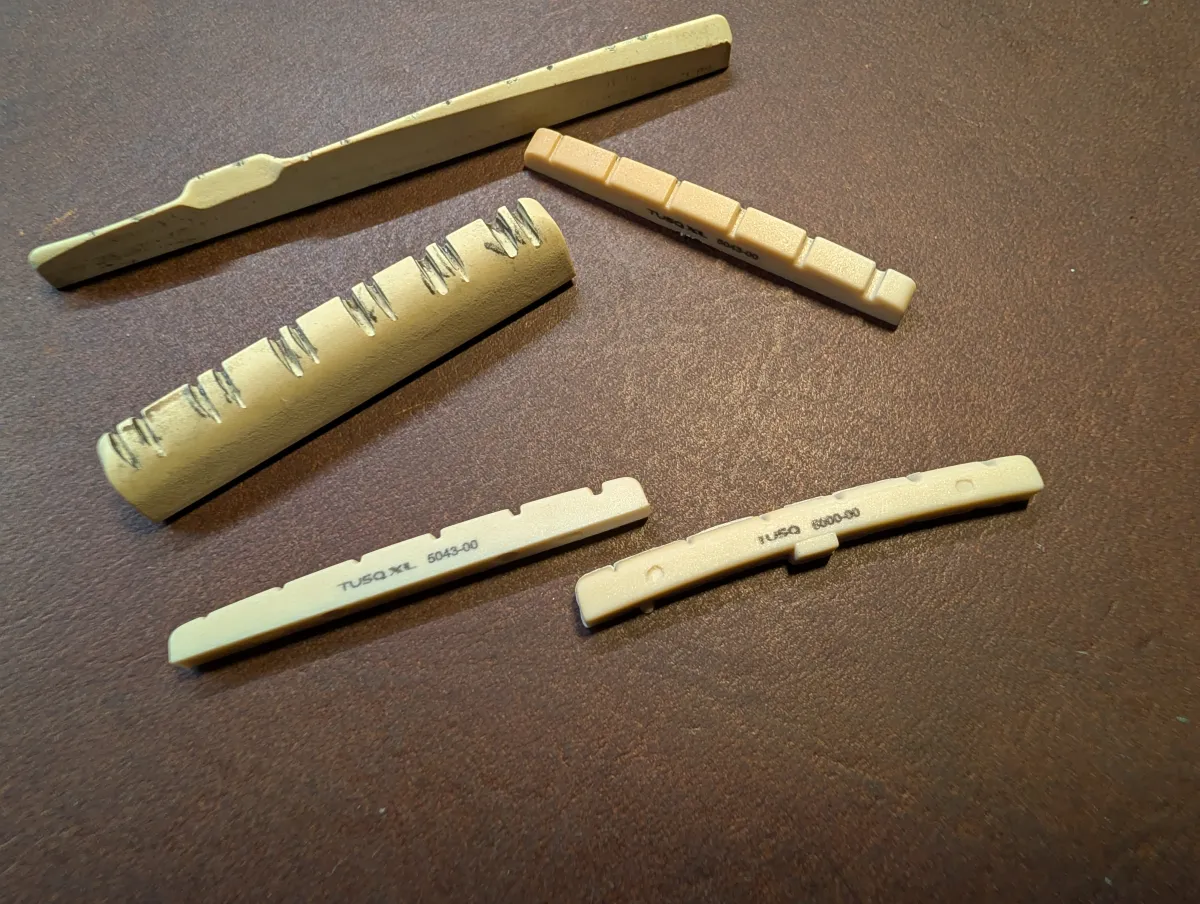 Hand-Carved Bone and TUSQ Guitar Nut on Artisan Workbench